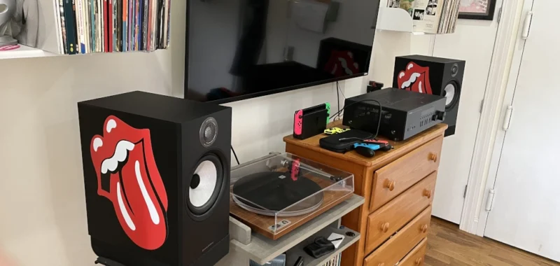 Yellow Audioengine S6 powered subwoofer on a walnut shelving unit